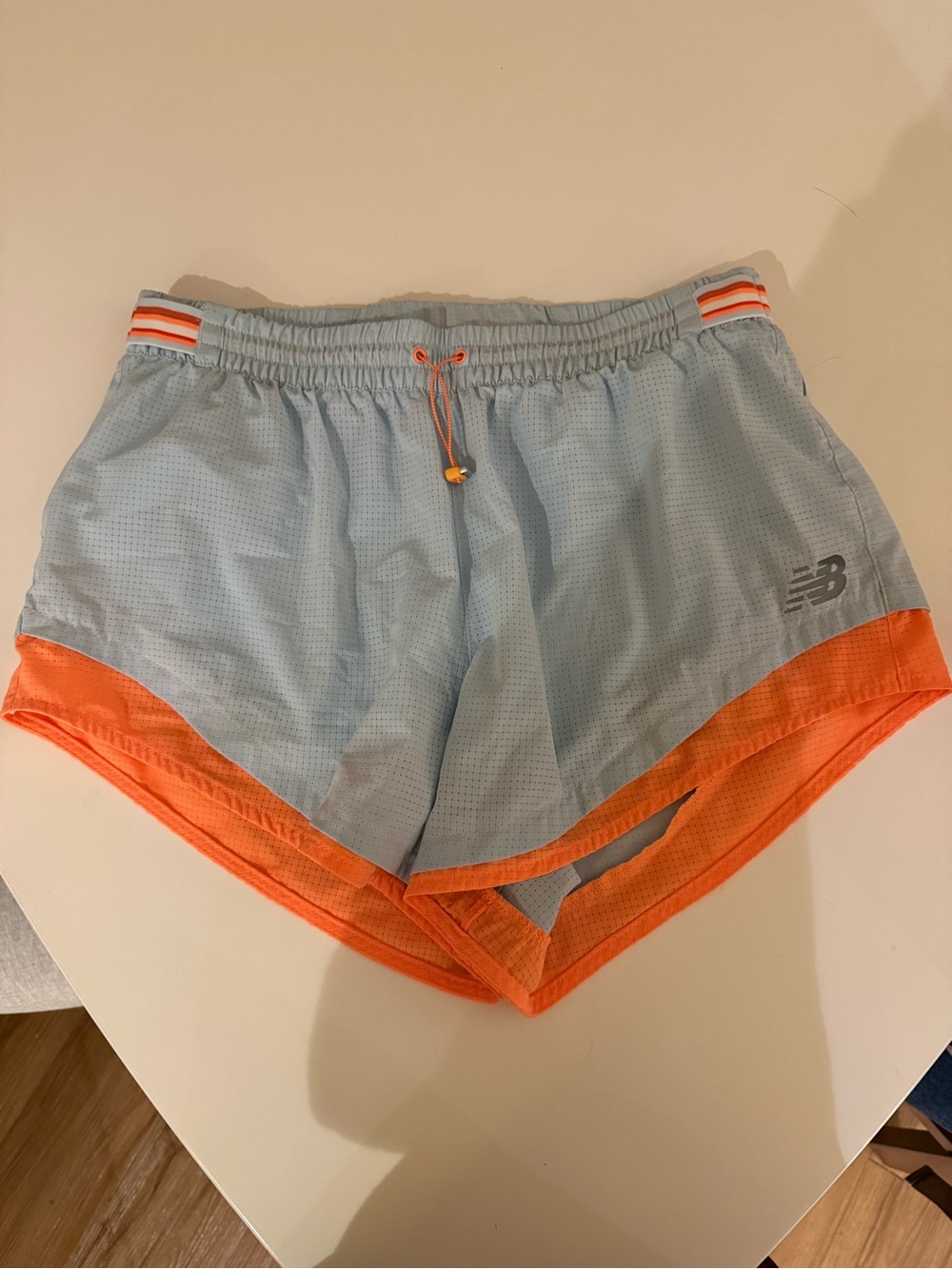 New Balance Pale Blue Running Shorts with Orange Logo
